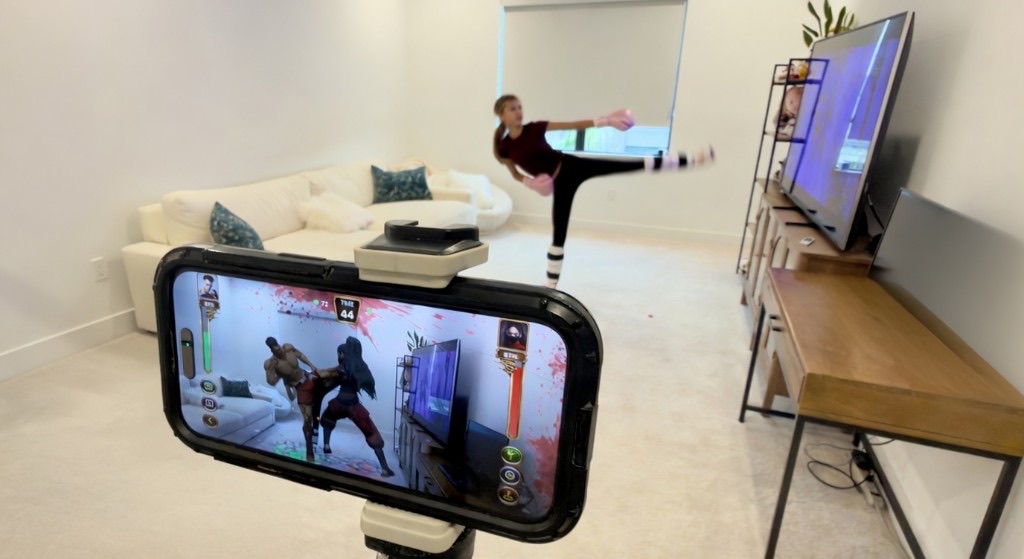 Phone view of AR fighters while a player kicks in the living room