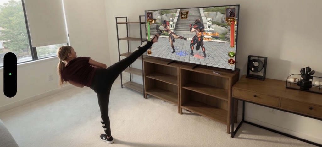 Player kicking toward TV with ARcade Arena on screen